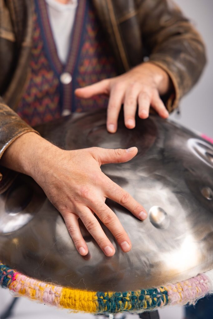Dettaglio delle mani che suonano un handpan