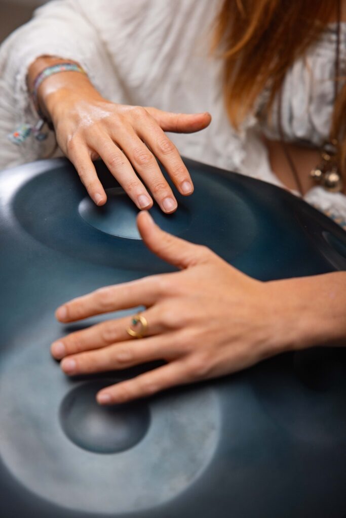Dettaglio dello strumento e delle mani sull’handpan